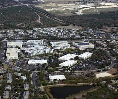 Aerial view of a corporate campus with a pond in the foreground